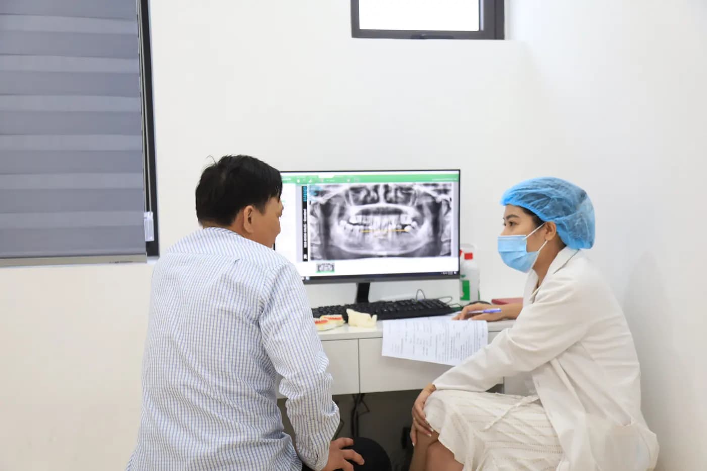 Bác sĩ giải thích phim X-quang cho khách trước khi lên kế hoạch điều trị