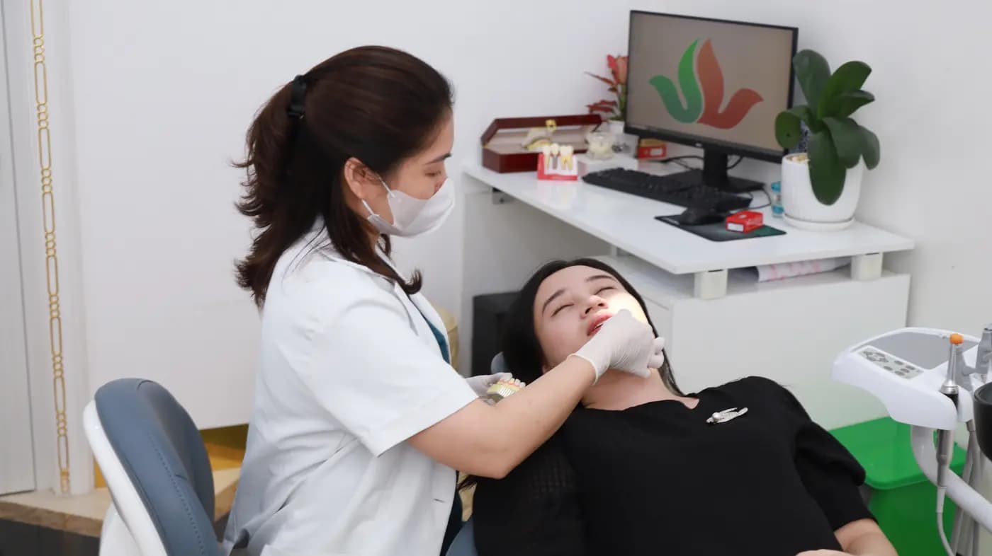A dentist examining a patient in the treatment chair